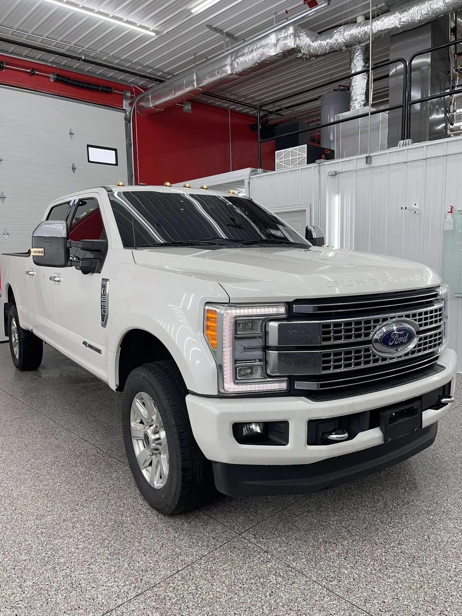 White Ford truck inside the tint installation bay